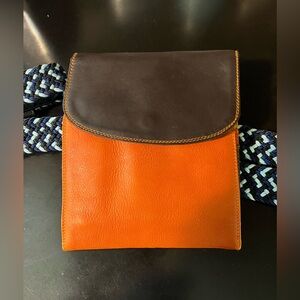 The OG of belt bags. Colorblock leather bag attaches to belt. Flap snap closure.